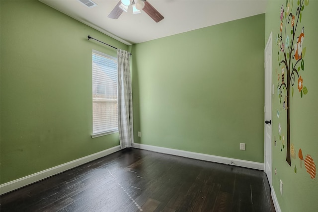 unfurnished room with ceiling fan, dark wood finished floors, visible vents, and baseboards