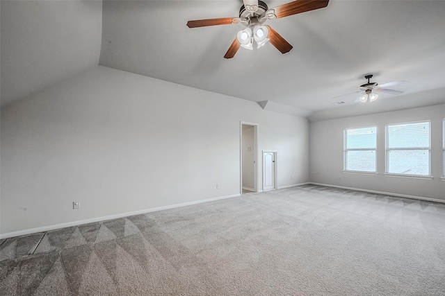 carpeted empty room featuring lofted ceiling and baseboards