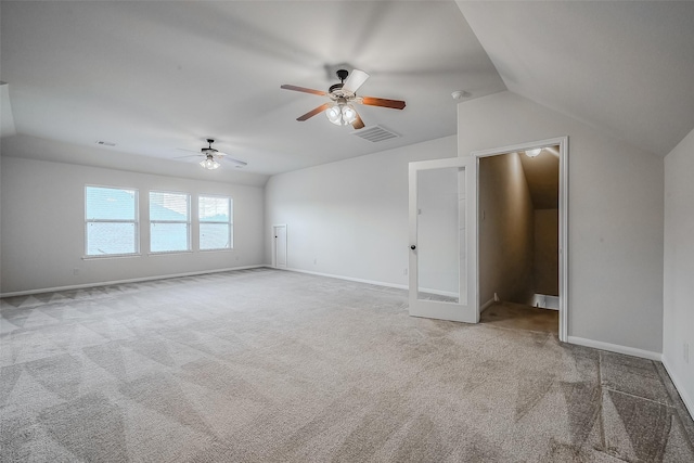 spare room with light carpet, baseboards, visible vents, and lofted ceiling