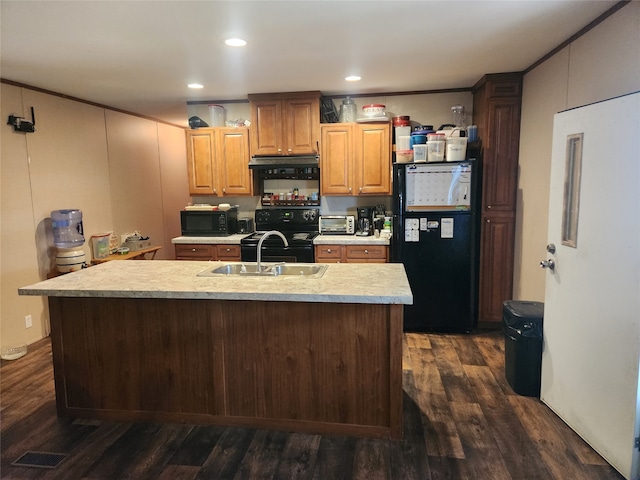 kitchen featuring dark wood-style floors, a kitchen island with sink, light countertops, black appliances, and recessed lighting