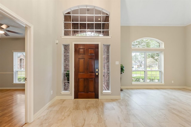 entryway featuring a high ceiling, baseboards, and a ceiling fan