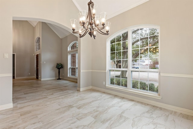 spare room with arched walkways, a wealth of natural light, and baseboards