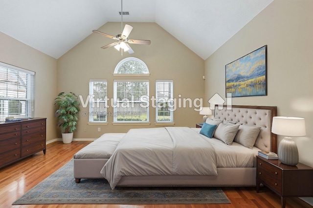 bedroom featuring high vaulted ceiling, visible vents, baseboards, and wood finished floors