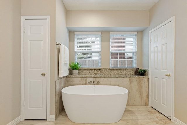 full bath with a freestanding bath and a closet