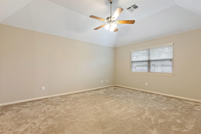 spare room featuring baseboards, visible vents, light colored carpet, lofted ceiling, and ceiling fan