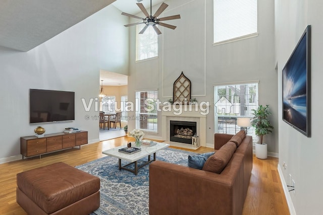 living room featuring a wealth of natural light, a fireplace, baseboards, and wood finished floors