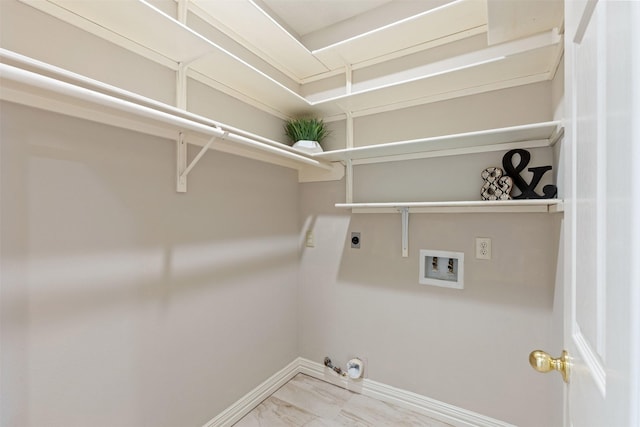 clothes washing area featuring hookup for an electric dryer, hookup for a gas dryer, laundry area, washer hookup, and baseboards