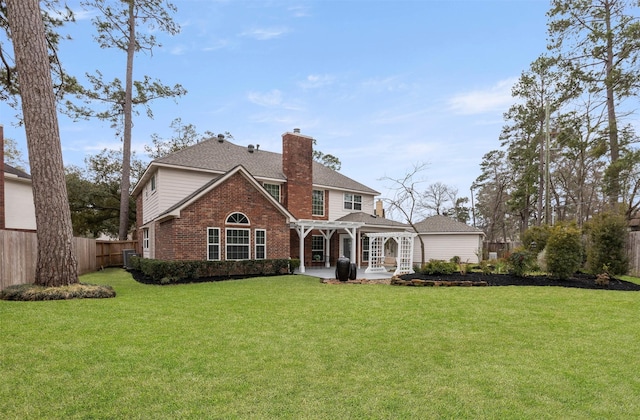 back of house with brick siding, fence, a lawn, a pergola, and a chimney