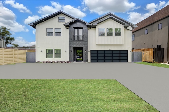 modern inspired farmhouse featuring an attached garage, fence, board and batten siding, and concrete driveway