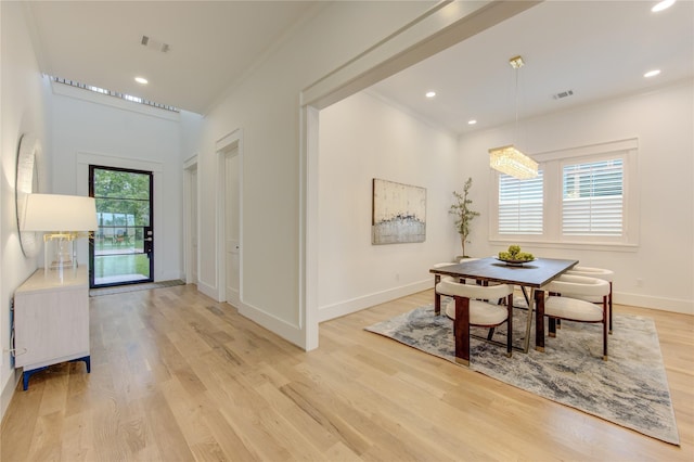 dining room with ornamental molding, visible vents, light wood-style floors, and baseboards