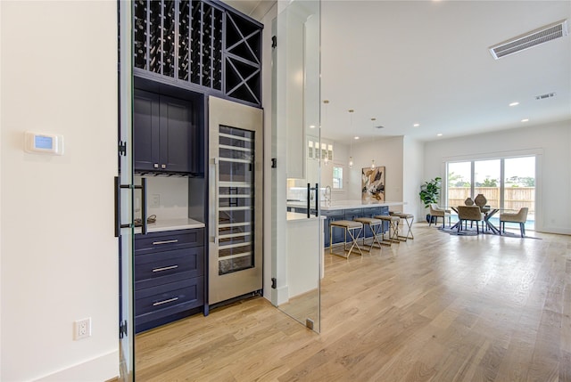 interior space featuring light wood-style floors, beverage cooler, visible vents, and recessed lighting