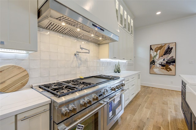 kitchen featuring light countertops, glass insert cabinets, white cabinetry, double oven range, and exhaust hood