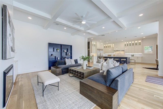 living room with light wood-type flooring, coffered ceiling, beam ceiling, and baseboards