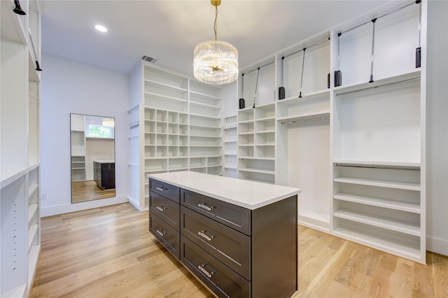 spacious closet featuring a chandelier, light wood-type flooring, and visible vents