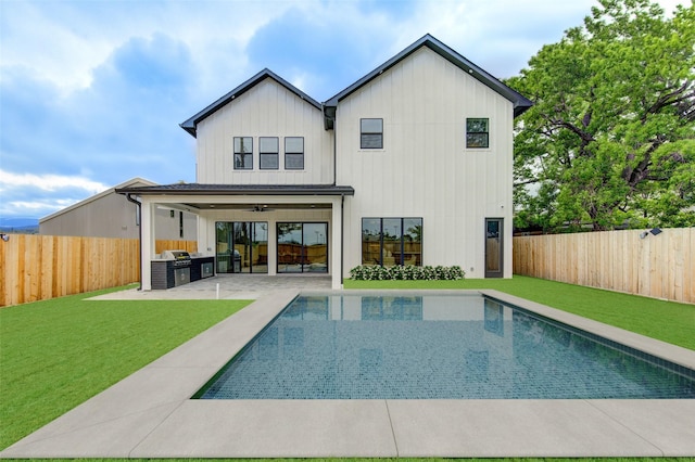 back of property with exterior kitchen, a patio area, a fenced backyard, and a yard