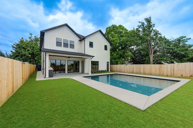 back of house featuring a ceiling fan, a fenced backyard, and a yard