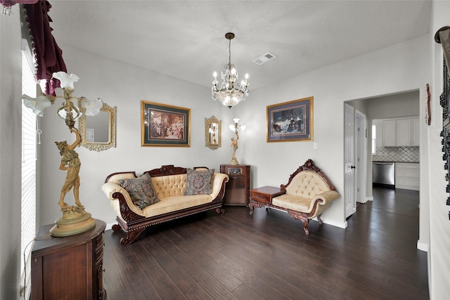 living area featuring dark wood-style floors, visible vents, and a chandelier