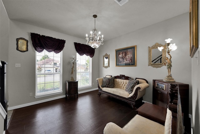 sitting room featuring a notable chandelier, dark wood finished floors, and baseboards