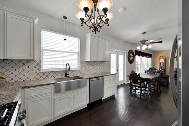 kitchen with dark wood finished floors, decorative light fixtures, stainless steel appliances, white cabinetry, and a sink