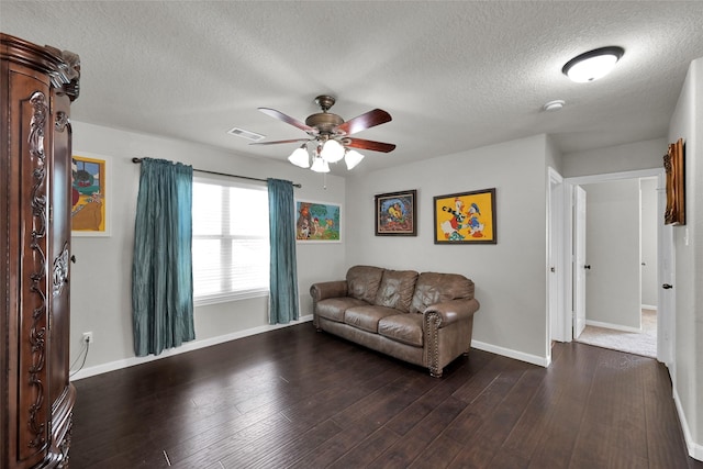 living area featuring dark wood-style floors, baseboards, visible vents, and a ceiling fan