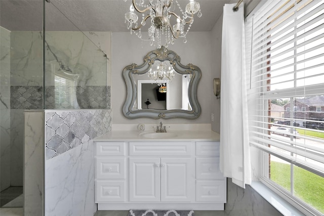 bathroom with walk in shower, vanity, and a notable chandelier