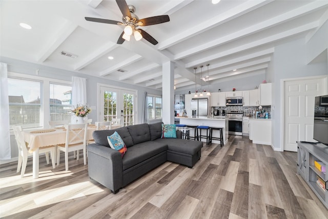 living area with vaulted ceiling with beams, recessed lighting, visible vents, french doors, and light wood finished floors