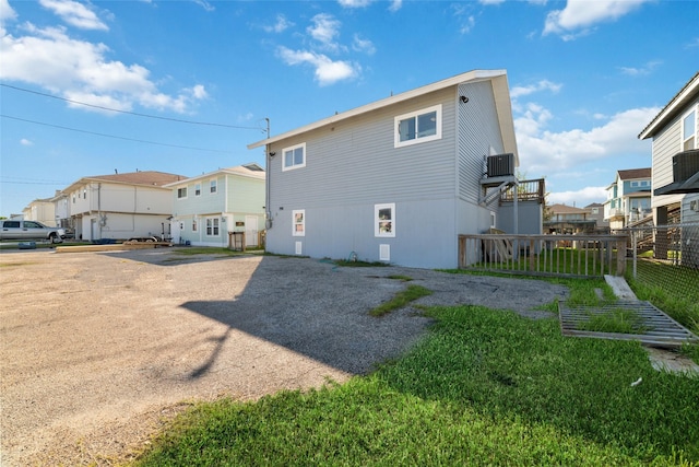 rear view of house with a residential view, fence, and central air condition unit