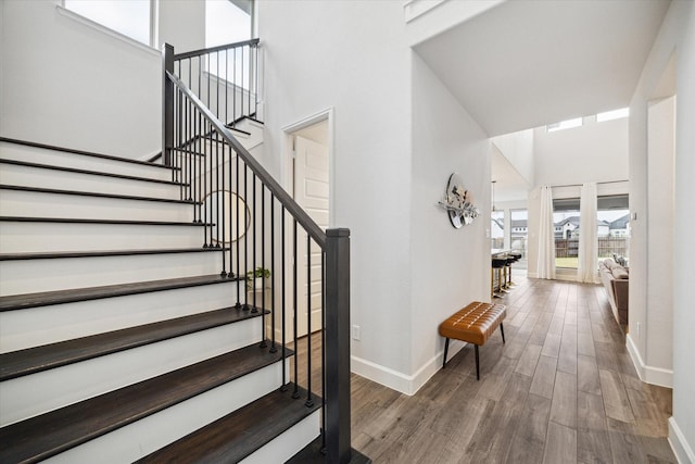 9410 Knollwood Ln, Missouri City, TX 77459 - staircase featuring wood finished floors, a towering ceiling, and baseboards