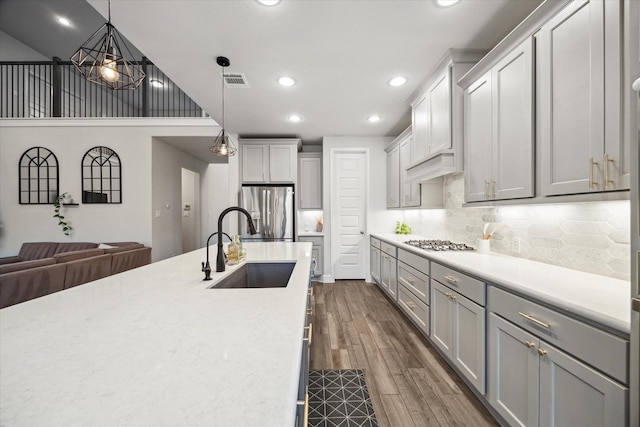 9410 Knollwood Ln, Missouri City, TX 77459 - kitchen featuring appliances with stainless steel finishes, open floor plan, light countertops, pendant lighting, and a sink