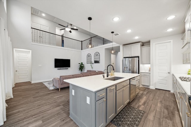 9410 Knollwood Ln, Missouri City, TX 77459 - kitchen featuring stainless steel appliances, a sink, open floor plan, light countertops, and a center island with sink