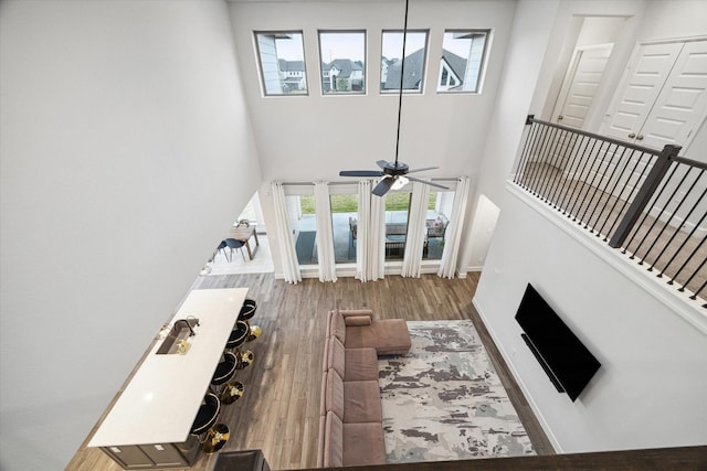 9410 Knollwood Ln, Missouri City, TX 77459 - living room with ceiling fan, wood finished floors, a towering ceiling, and baseboards