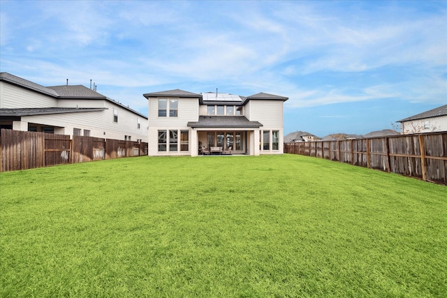 9410 Knollwood Ln, Missouri City, TX 77459 - back of house with a fenced backyard, roof mounted solar panels, and a yard