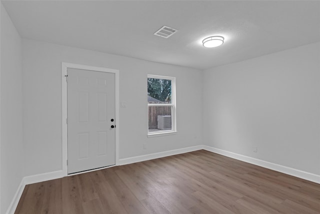 empty room featuring light wood-style floors, baseboards, and visible vents