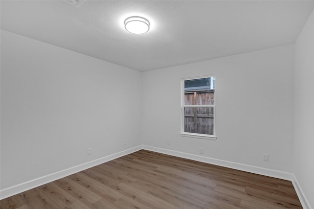 empty room featuring baseboards and wood finished floors