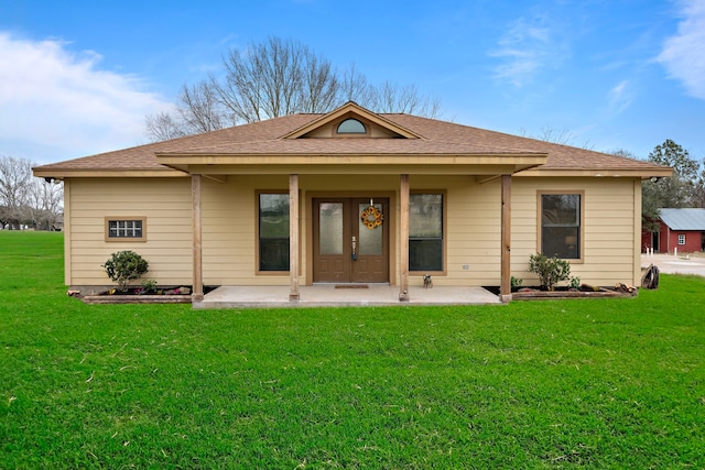 back of house with french doors and a yard