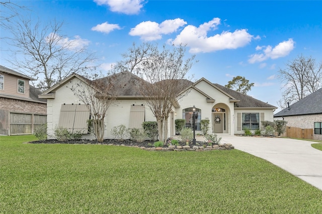 view of front facade with fence, concrete driveway, and a front yard