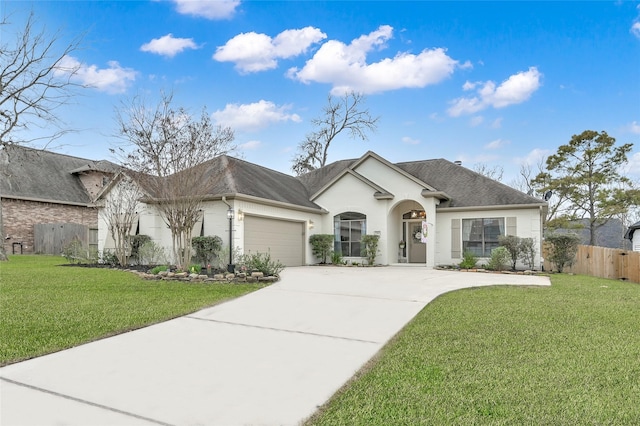 view of front of home featuring an attached garage, driveway, fence, and a front yard