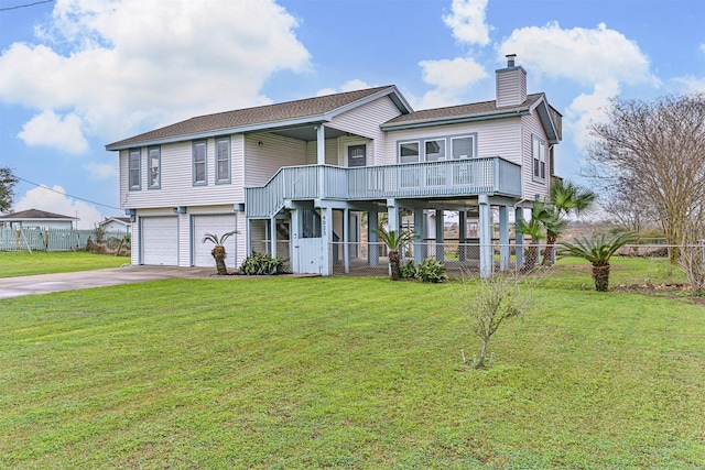 view of front facade featuring a front yard, driveway, a chimney, and an attached garage