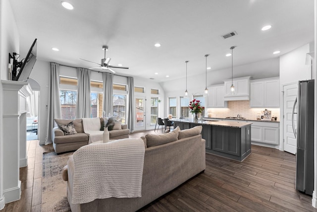 living area featuring a ceiling fan, dark wood-style flooring, visible vents, and recessed lighting