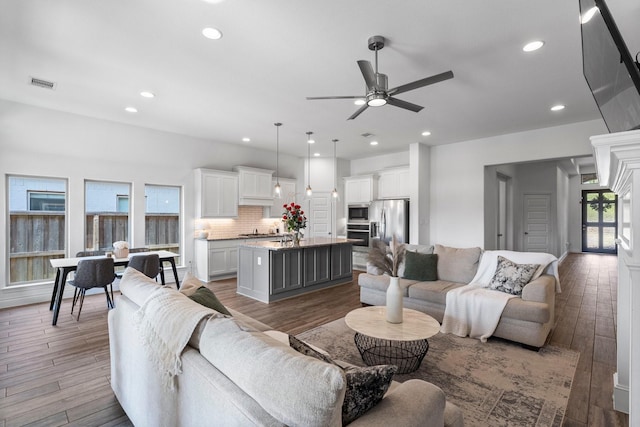 living room with a ceiling fan, dark wood finished floors, visible vents, and recessed lighting