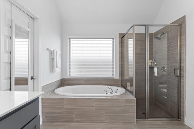 full bathroom featuring a bath, a shower stall, and vanity