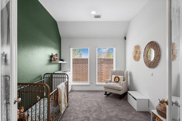 carpeted bedroom with a nursery area, lofted ceiling, and visible vents