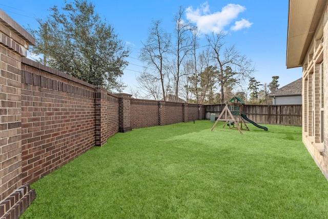 view of yard with a playground and a fenced backyard