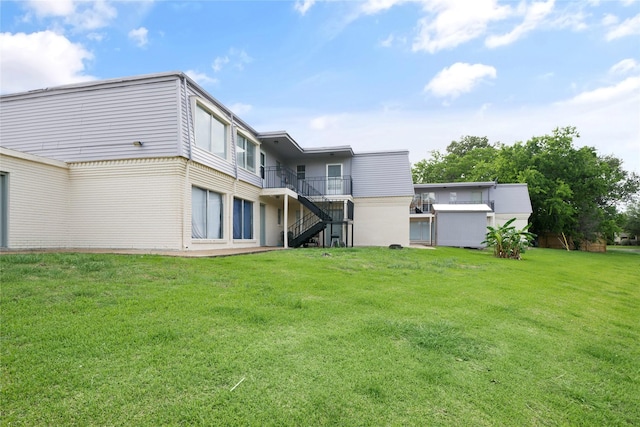 rear view of property featuring stairs and a lawn