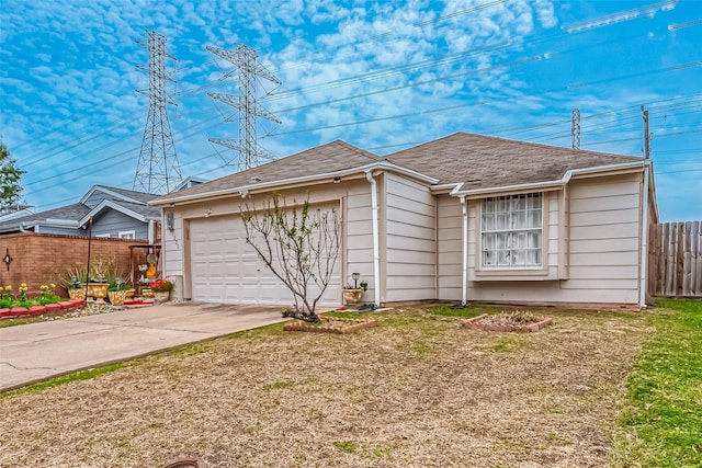 view of front of home with driveway, a garage, fence, and a front lawn