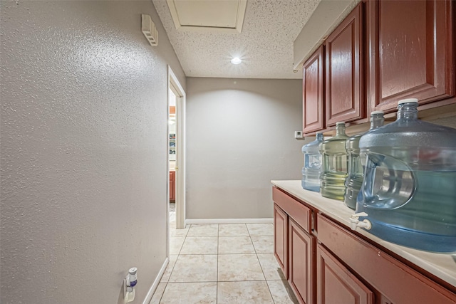 9319 Belle Park Dr, Houston, TX 77099 - interior space featuring light tile patterned floors, light countertops, a textured wall, a textured ceiling, and baseboards