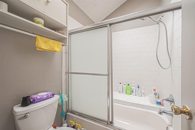 9319 Belle Park Dr, Houston, TX 77099 - full bathroom featuring a textured wall, combined bath / shower with glass door, vaulted ceiling, and toilet