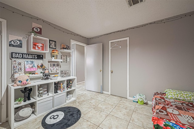 9319 Belle Park Dr, Houston, TX 77099 - rec room with visible vents, a textured ceiling, baseboards, and light tile patterned flooring