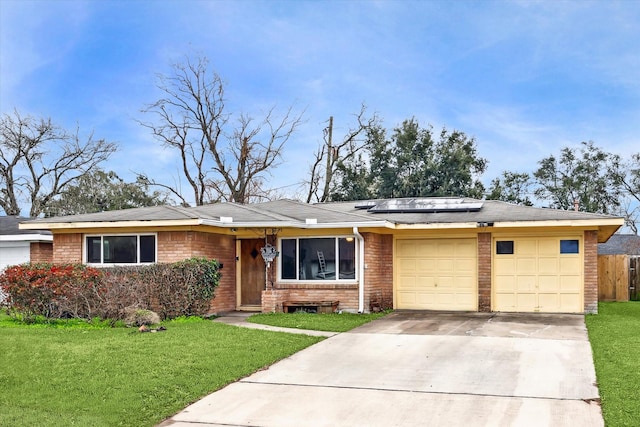 single story home with concrete driveway, brick siding, a front lawn, and an attached garage