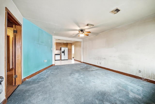 unfurnished living room featuring a ceiling fan, light carpet, visible vents, and baseboards